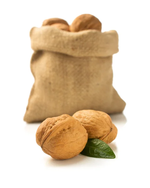 Vlašské ořechy ve vaku na bílém pozadí — Stock fotografie