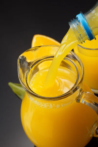 Jarra de cristal y zumo de naranja en negro —  Fotos de Stock