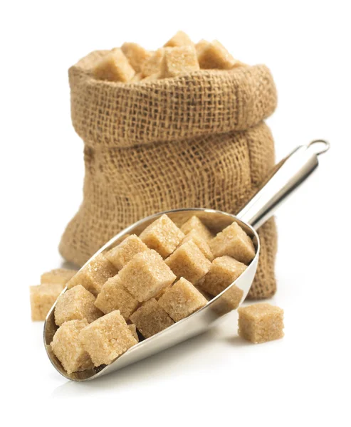 Brown sugar cubes in scoop on white — Stock Photo, Image