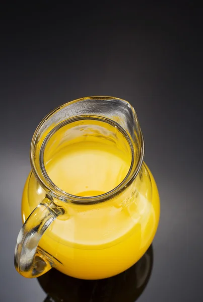 Jarro de vidro e suco de laranja em preto — Fotografia de Stock