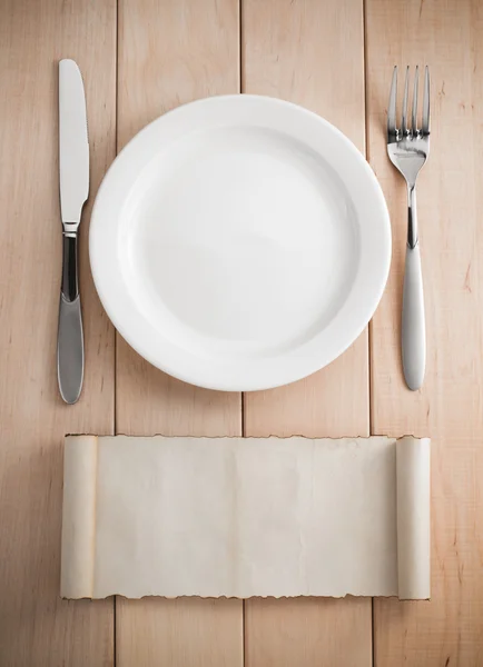 Assiette, couteau et fourchette sur bois — Photo