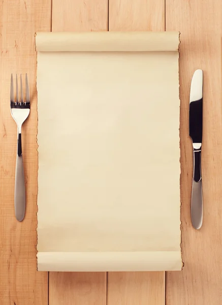 Parchment and fork with knife on wood — Stock Photo, Image