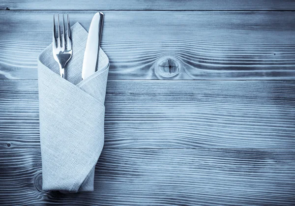 Kniv och gaffel på servett på trä — Stockfoto