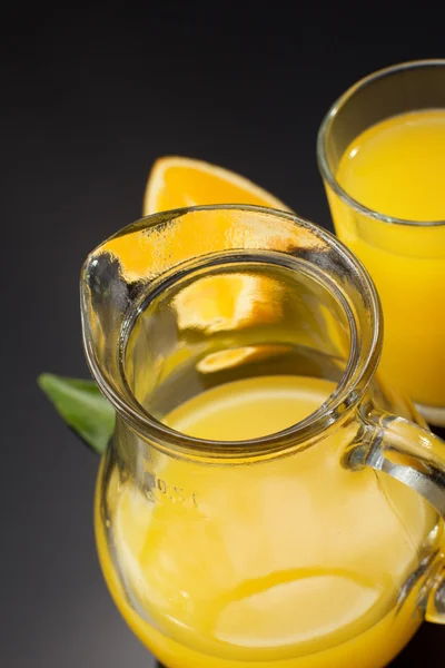 Orange juice and fruit on black — Stock Photo, Image