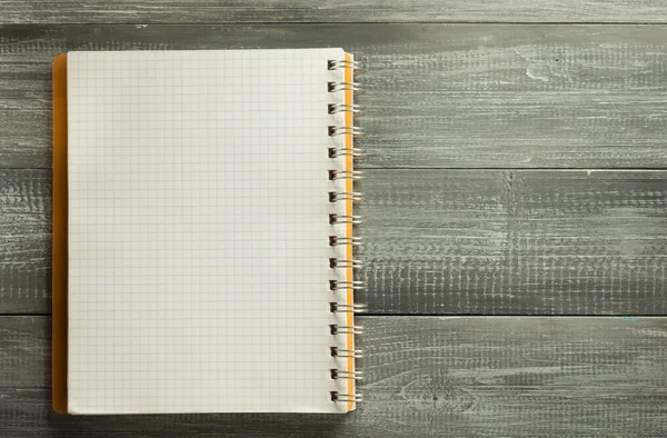 Cuaderno comprobado sobre mesa de madera — Foto de Stock