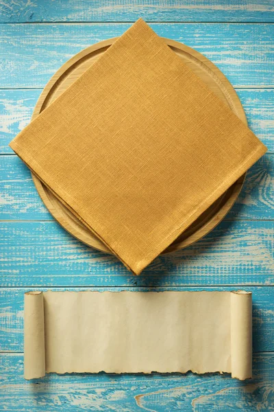 Napkin and board on wooden background — Stock Photo, Image