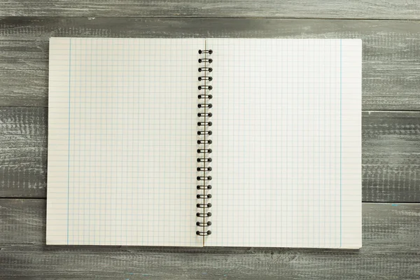 Cuaderno comprobado sobre mesa de madera —  Fotos de Stock