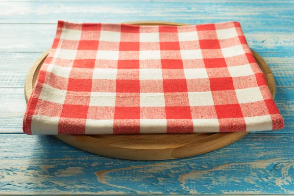 Napkin and board on wooden background — Stock Photo, Image