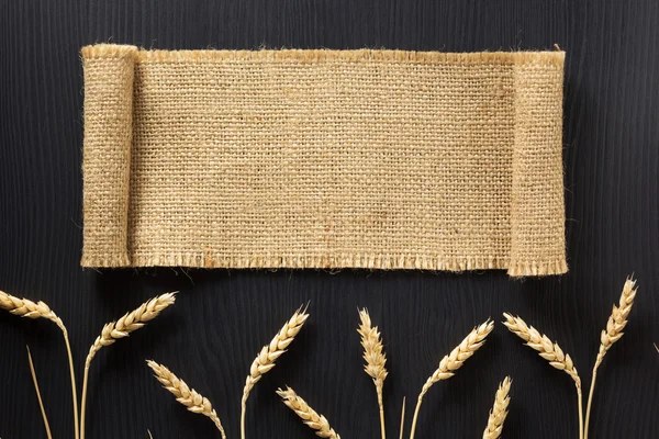 Espigas de trigo e pano sobre madeira — Fotografia de Stock