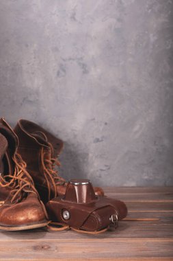 seyahat eski ayakkabı ahşap masa ve retro kamera, beton duvar arkaplan dokusu yüzey