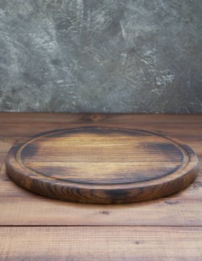 Tahta masada pizza kesme tahtası, duvar arkası desenli.