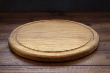Tahta masada pizza kesme tahtası, duvar arkası desenli.