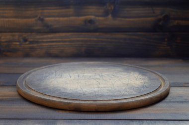 pizza cutting board at wooden table, with wood background texture