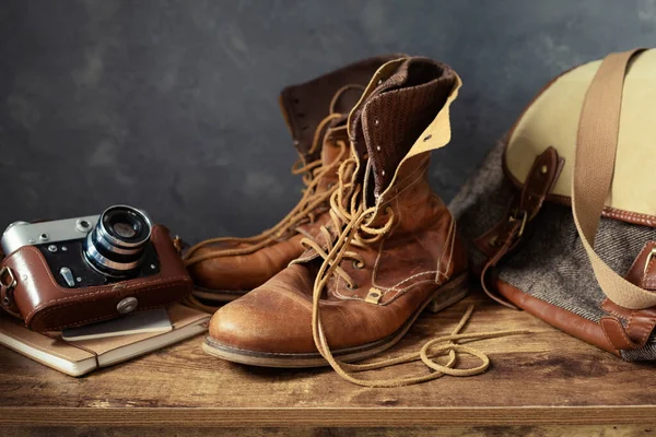古い革旅行ヴィンテージブーツ靴とバッグで木製テーブル 壁の背景テクスチャ — ストック写真