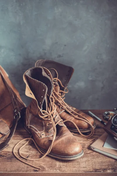 古い旅行ヴィンテージブーツの靴と革のバッグ木製のテーブルで 壁の背景のテクスチャ — ストック写真
