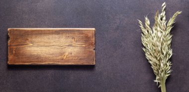 Masada bir demet yulaf var. Taştan kırsal arkaplan dokusunda doğal gıda konsepti. Düz panoramia ya da panoramik üst görünüm