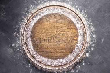 Tahta pizzada buğday unu ya da masada pişirmek için ekmek kesme tahtası. Gıda tarifi konsepti, arka plan dokusunda fotokopi alanı ile. Düz üst görünüm