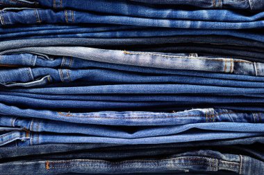 Arka plan dokusu olarak kot pantolon yığını veya yığını. Katlanmış kot pantolon yığını.