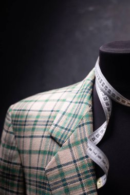 Erkek terzi mankeni ve mezura üzerindeki takım elbise ceketi, yaratıcı kıyafet atölyesi konsepti