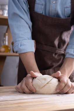 Fırıncı adam hamur yoğurur veya hamur ve fırın malzemeleri yapar Rafta ev yapımı ekmek pişirir. Duvar arkaplanı dokusu yakınında fırın kavramı