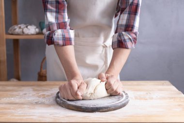 Fırıncı adam hamur yoğurur veya hamur ve fırın malzemeleri yapar Rafta ev yapımı ekmek pişirir. Duvar arkaplanı dokusu yakınında fırın kavramı