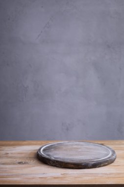 Pizza ya da ekmek kesme tahtası ve ev yapımı pişirme için buğday unu tozu gri duvarın yanındaki ahşap masada. Yemek tarifi konsepti ahşap arkaplan dokusunda fotokopi alanı ile. Ön görünüm