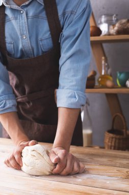 Fırıncı adam hamur yoğurur veya hamur ve fırın malzemeleri yapar Rafta ev yapımı ekmek pişirir. Duvar arkaplanı dokusu yakınında fırın kavramı