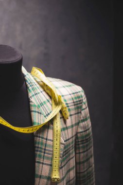 Erkek terzi mankeni ve mezura üzerindeki takım elbise ceketi, yaratıcı kıyafet atölyesi konsepti