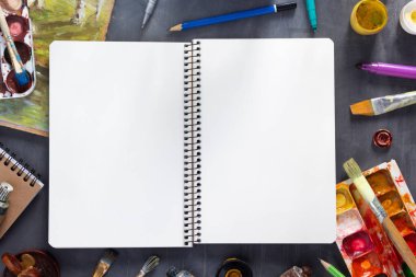 Boya fırçasında eskiz kitabı ve soyut masa arkaplan dokusunda boyama aletleriyle tüpler. Sanat ressamı konsepti ve boya fırçası