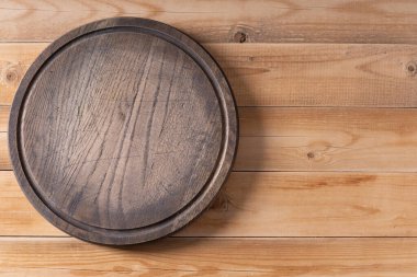 Masada ev yapımı pişirme için et ya da ekmek dilimleme tahtası. Pizza tahtası ahşap masa arkaplan dokusunda fotokopi alanı ile. Düz üst görünüm