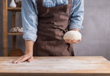 Fırıncı adam yoğurur, hamur ya da ekmek pişirir. Fırın konsepti ve ahşap masa arkaplan dokusu