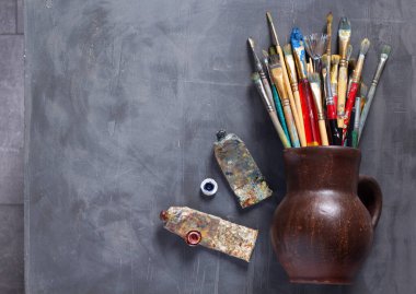 Soyut masa arkaplan dokusunda eski boya fırçası ve tüpler. Sanat ressamı konsepti ve araçları