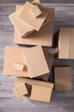 Zemin kaplamasında karton kutu yığını. Yeni eve taşınmak için karton kutular. Yer değiştirme konsepti üst görünüm