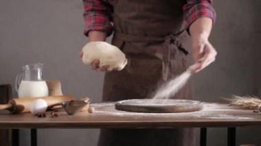 Fırıncı adam masada ev yapımı ekmek pişirmek için hamur ve fırın malzemeleri yapıyor. Fırın konsepti ve erkek eli