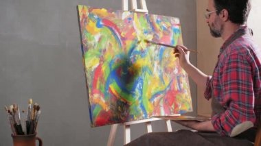 Erkek sanatçı resim üzerinde çalışıyor. Sanat konsepti olarak yaratıcı stüdyoda sanatçı adam.