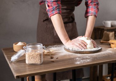 Aşçı adam masada ev yapımı ekmek pişirmek için hamur ve fırın malzemeleri yapıyor. Fırın konsepti ve erkek eli