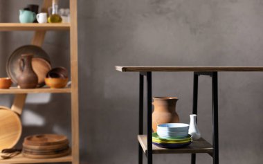 Mutfak odası ve boş çanak çömlek ya da seramik tabak seti. Duvar arkası dokusu yanında ahşap masa bulunan kil bulaşık takımı ve sofra takımı