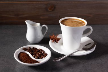 Bir fincan kahve ve arkaplan dokusunda malzeme olan fasulye. Kahve molası kavramı.