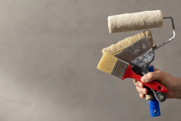 建筑工人持油漆辊工具靠近混凝土或灰泥墙 室内装修用的男性手和施工工具 家庭翻新概念 — 图库照片