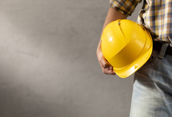 Man worker holding construction helmet near plater wall. Male hand and construction tools. Renovation or repair concept