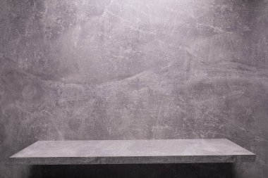 Soyut gri taş arkaplan dokusu ve duvardaki raf. Duvar arkaplan yüzeyinde kitap rafı