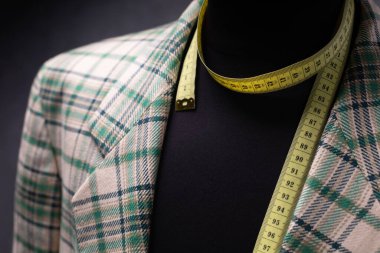 Erkek terzi mankeni ve mezura üzerindeki takım elbise ceketi, yaratıcı kıyafet atölyesi konsepti