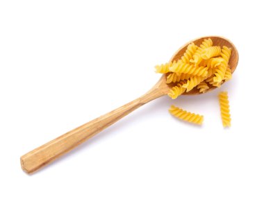 Beyaz kaşıkta çiğ makarna. Beyaz arkaplanda makarna fusili