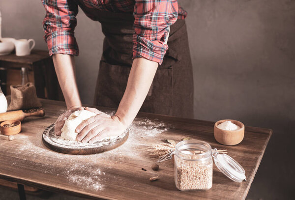 Baker man making dough and bakery ingredients for homemade bread cooking on table. Bakery concept and male hand