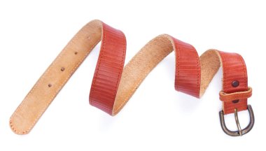 Beyaz arka planda izole edilmiş kırmızı deri kemer. Tokalı eski püskü bir kemer.