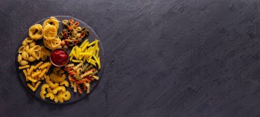 Masa arkasında makarna toplama yemeği. Slate Stone Masası 'nda çiğ makarna çeşitleri