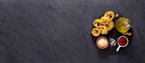 テーブルの上のパスタ食品成分 生パスタフェットチーネでスレート石のテーブルトップ — ストック写真