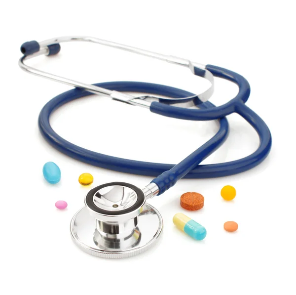 Medical stethoscope with pills on white — Stock Photo, Image