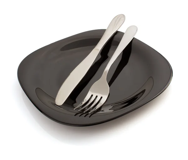 Mes en vork op plaat op wit — Stockfoto