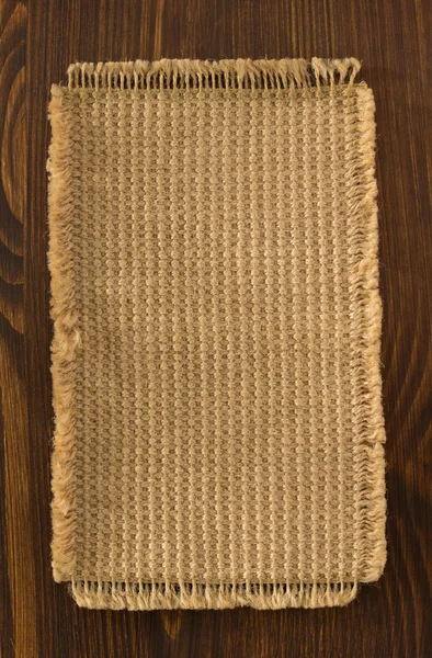 Burlap hessian sack on wood — Stock Photo, Image